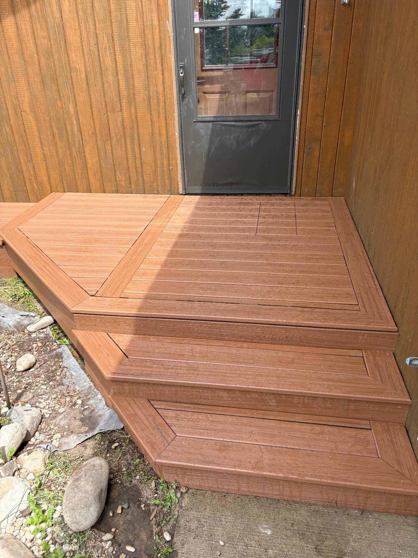 Composite entry stairs beside black door